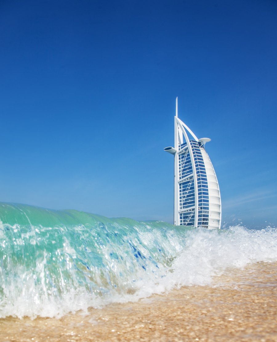 Le Burj Al Arab derrière une vague turquoise sur la plage de Dubaï