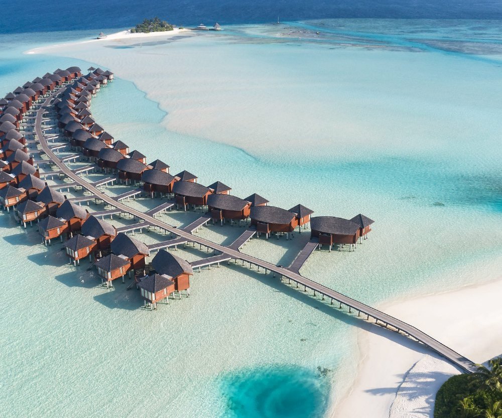Alignement de villas sur pilotis et lagon turquoise, vus du ciel